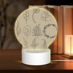 Round Acrylic Night Light, A Collection Of Leaves And Flowers Drawn In Black And White.