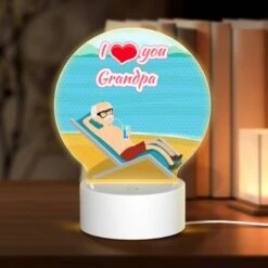 Round Acrylic Night Light, A Man Is Sitting On A Beach Chair With A Drink In His Hand.