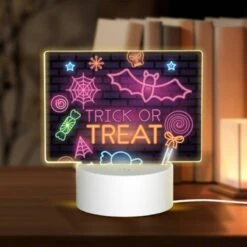 Rectangular Acrylic Night Light, A Neon Sign That Says "trick Or Treat" On A Brick Wall.