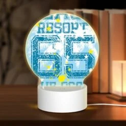 Round Acrylic Night Light, A Blue And Yellow Shirt With The Number 66 On It.