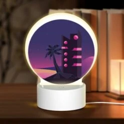 Round Acrylic Night Light, A Tall Building With A Pink And Black Color Scheme Is Lit Up At Night.